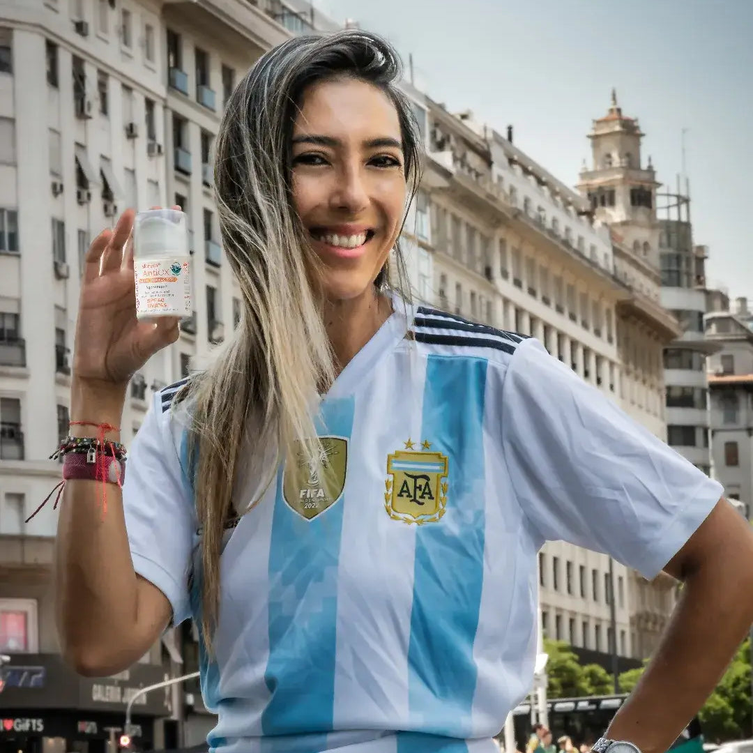 skinara brand ambassador in Argentina soccer jersey holding Agescreen sunscreen in Buenos Aires