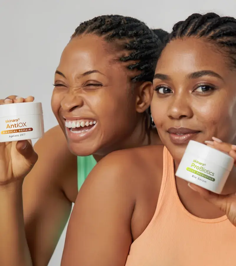 Two happy women holding antioxidant skin care best before and after sun anti pigmentation creams