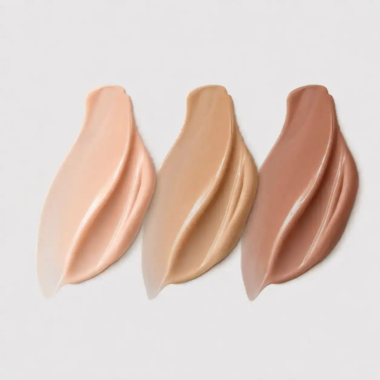 Three swatches of skinara tinted sunscreen shades in light peach, tan, and medium brown shades, for all skin tones