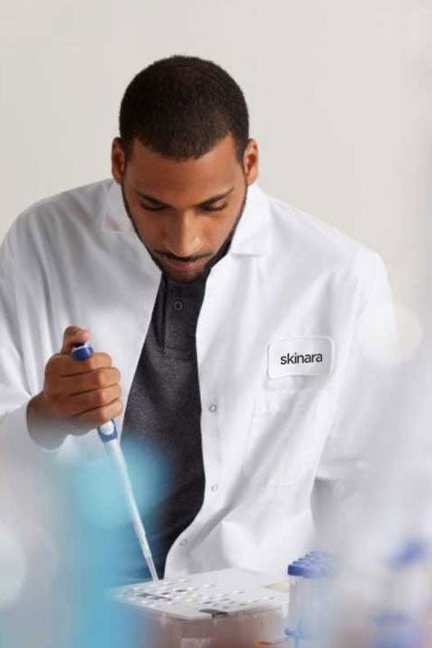 Lab technician in a lab coat working at Skinara microbiology lab on biotics research