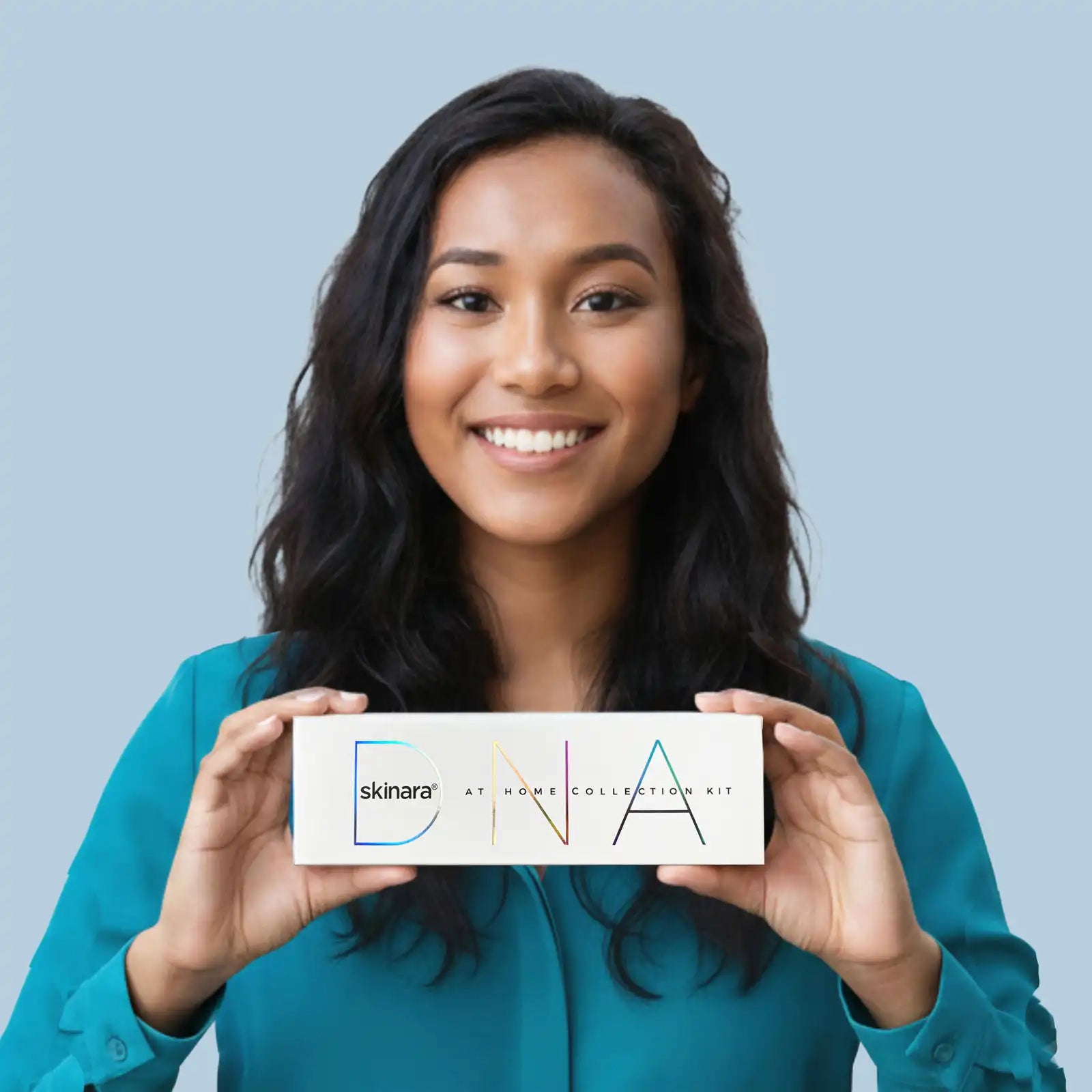Woman holding a skinara genetic methylation DNA testing kit against a light blue background