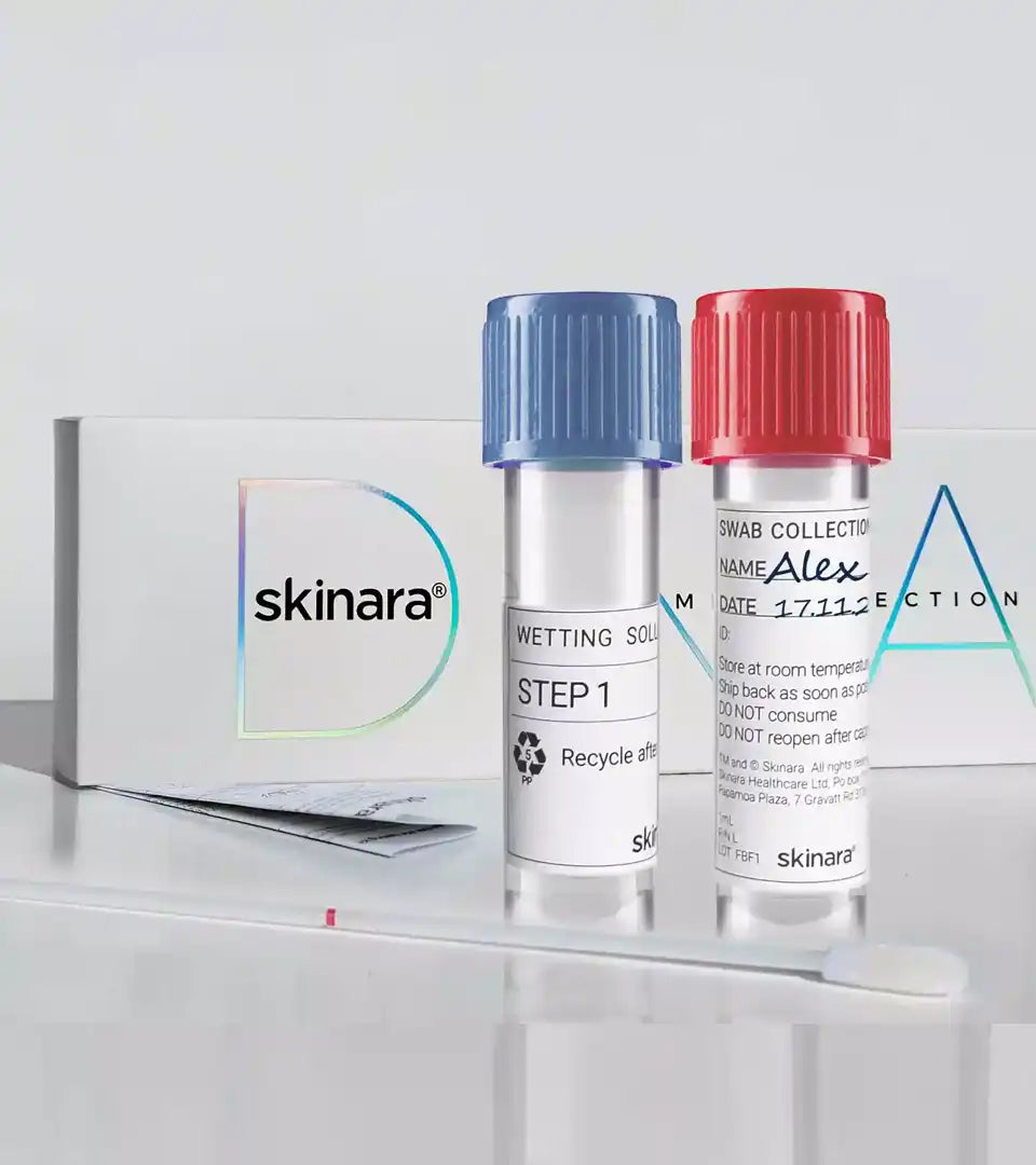 Skinara skin DNA test kit wetting solution and sample bottles with the kit pack behiind them on a white background