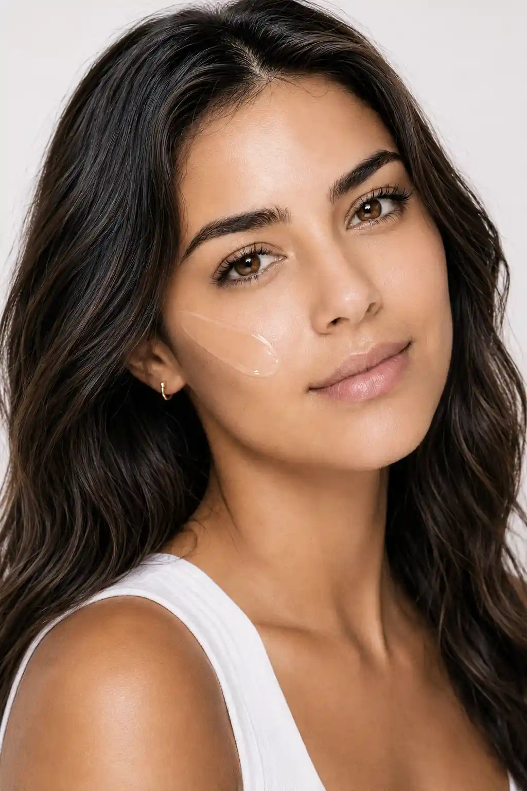 Woman blending AgeScreen Clear sunscreen into her skin