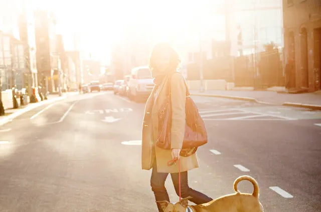Woman wearing broad spectrum sunscreen walking her dog
