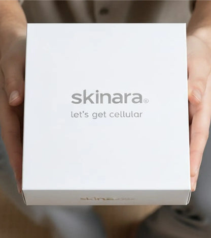 man holding a white skinara branded white box out in front of him