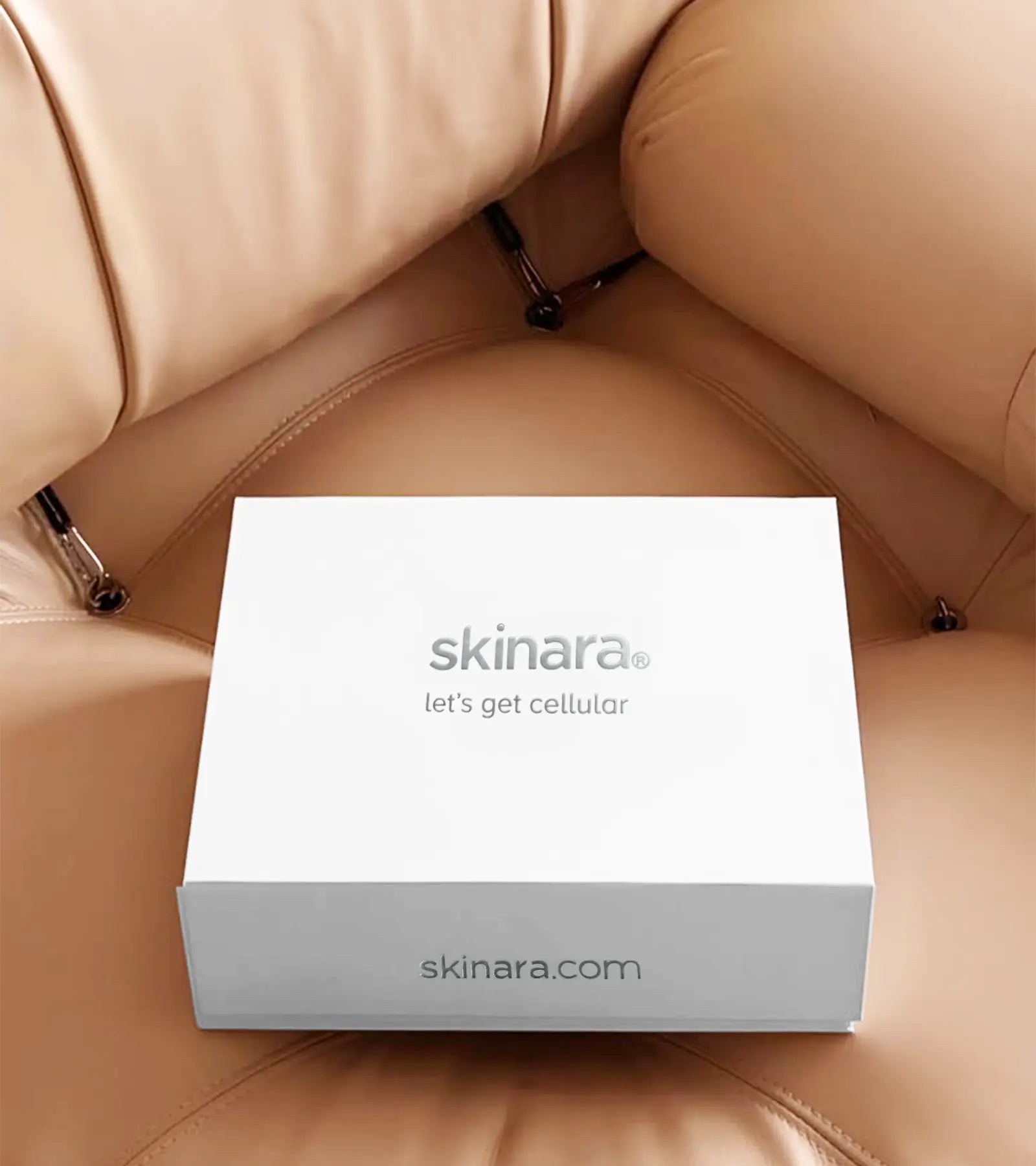 A white box with 'skinara' branding on a beige leather chair