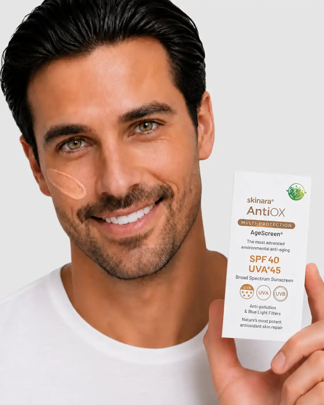 Man model with medium olive skin wearing Mocca AgeScreen tint and holding the SPF product