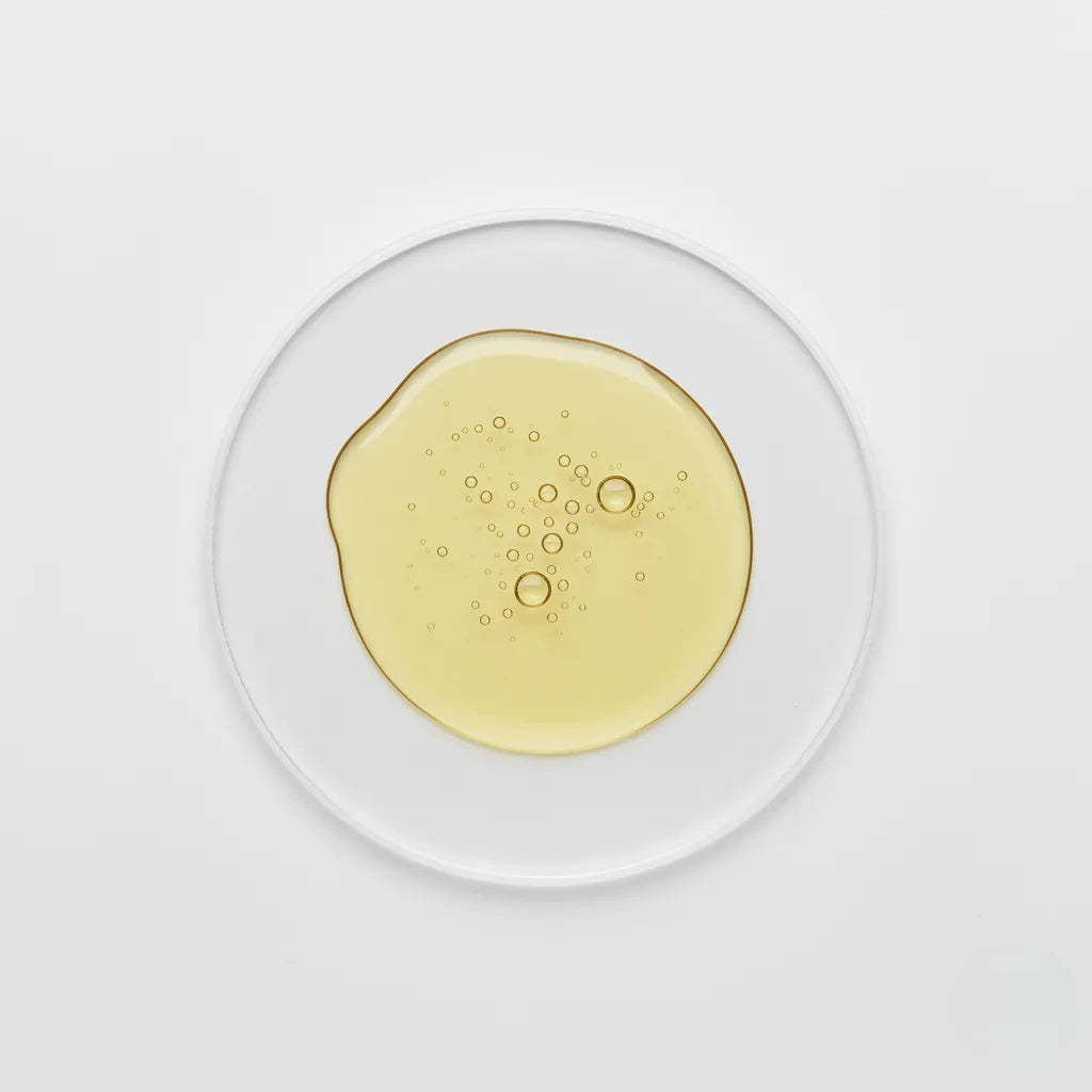 vitamin E oil with bubbles on a clear glass plate against a white background