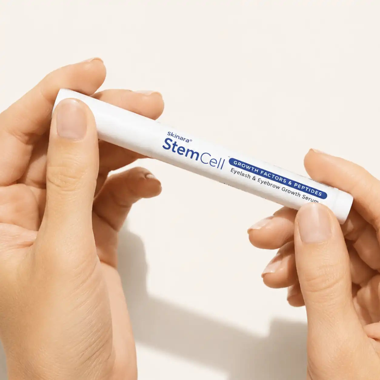 Hands opening a Skinara StemCell lash and brow serum applicator