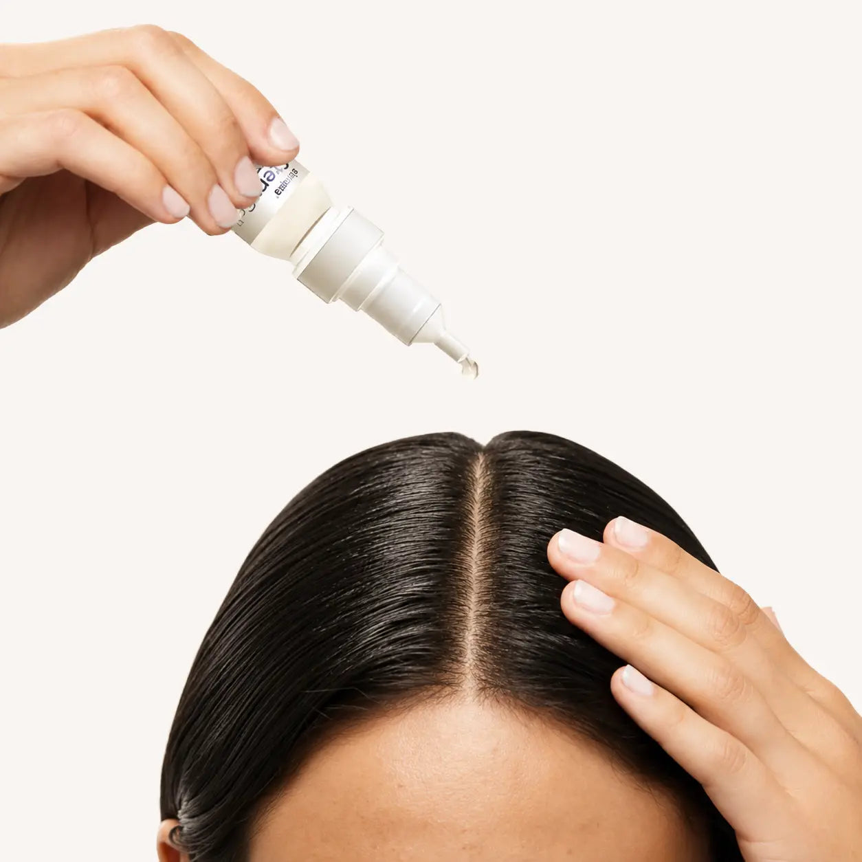 Skinara professional scalp serum being applied along a client’s hair part