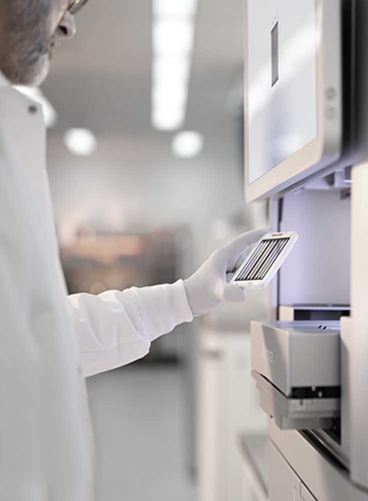 Person in a lab coat using a tablet in a Illumina laboratory setting