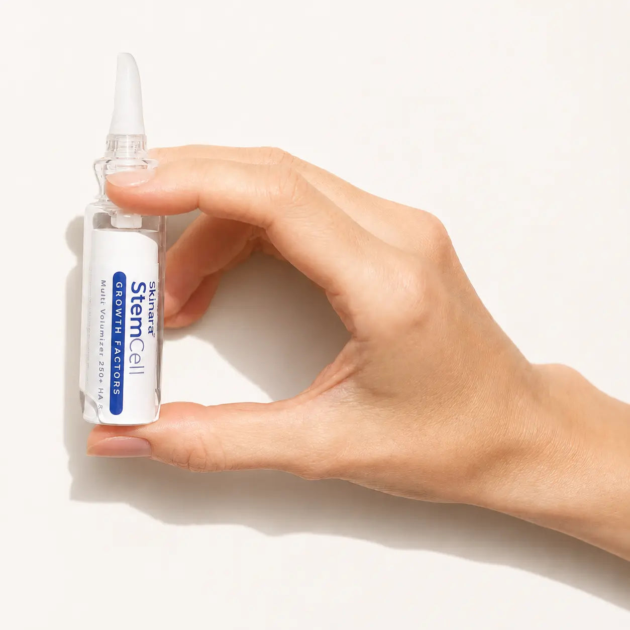 Professional holding a Skinara StemCell serum ampoule